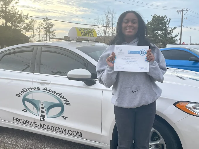 Un estudiante de ProDrive Academy junto a uno de los autos de la escuela