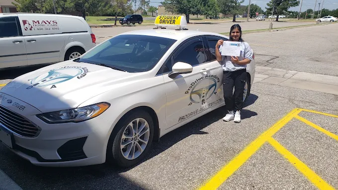 Un estudiante de ProDrive Academy junto a uno de los autos de la escuela