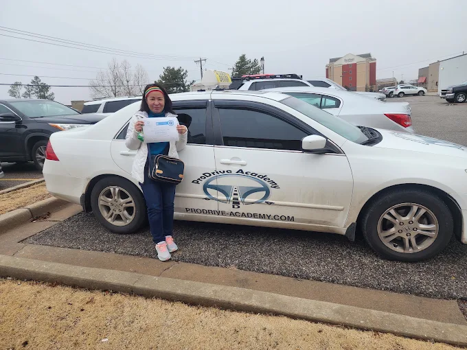 Un estudiante de ProDrive Academy junto a uno de los autos de la escuela