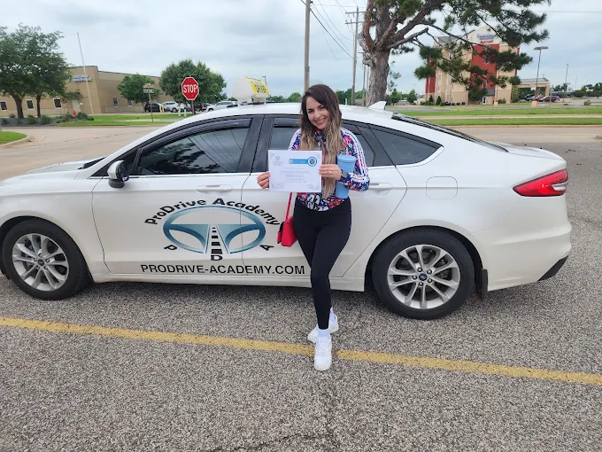 Un estudiante de ProDrive Academy junto a uno de los autos de la escuela