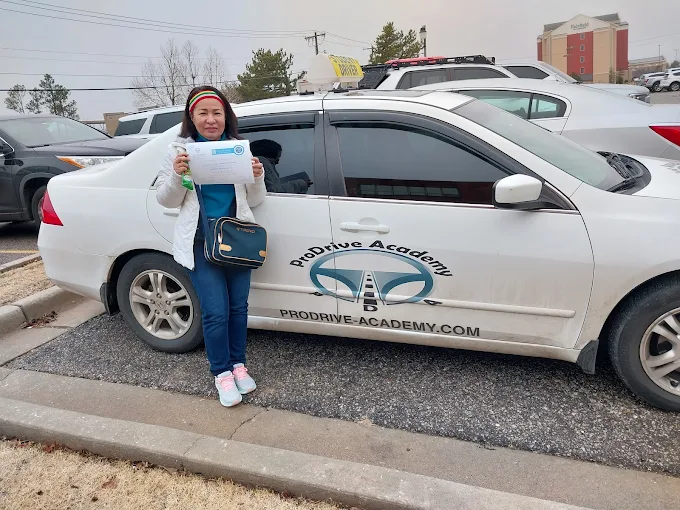 Un estudiante de ProDrive Academy junto a uno de los autos de la escuela