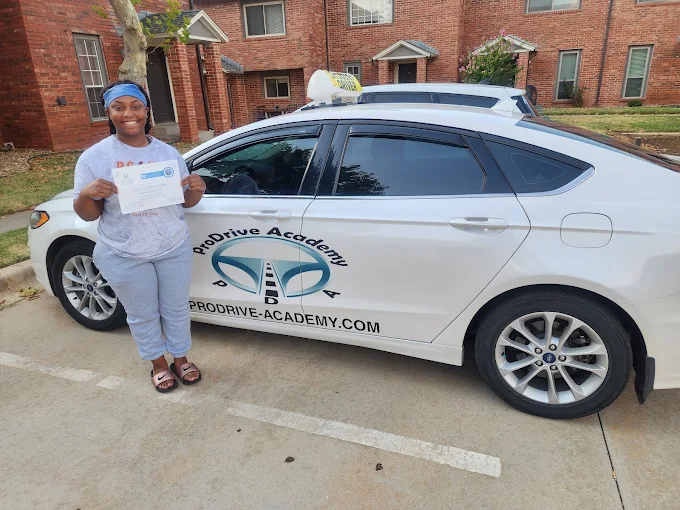 Un estudiante de ProDrive Academy junto a uno de los autos de la escuela
