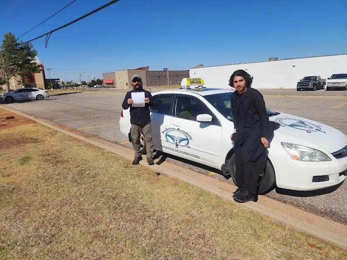 Un estudiante de ProDrive Academy junto a uno de los autos de la escuela