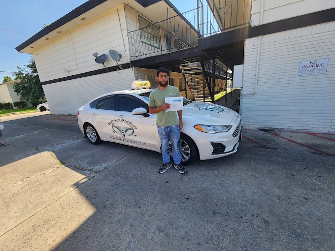 Un estudiante de ProDrive Academy junto a uno de los autos de la escuela