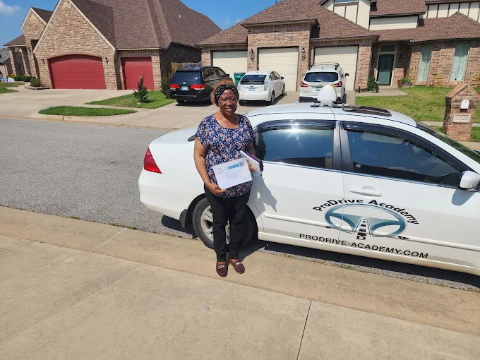 Un estudiante de ProDrive Academy junto a uno de los autos de la escuela